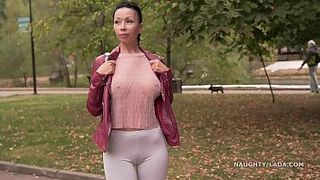 Тёлка в леггинсах гуляет по парку без трусиков и показывает большие дойки